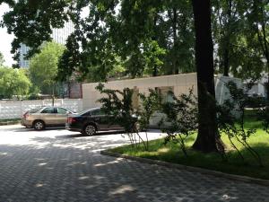 dos autos estacionados en un estacionamiento al lado de un edificio en Business Hotel Alekseevsky en Moscú