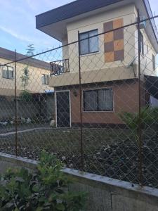 a chain link fence in front of a house at Pines Mansion 2 Homestay for Rent in Cash with 30 percent Advance Payment to Confirm in Butuan
