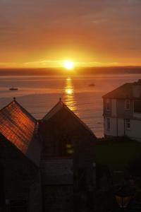 a sunset over the ocean with houses in the foreground at The Loft in St Ives