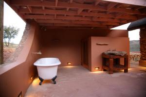 a bathroom with a bath tub and a table at Meijer's Rust in De Rust