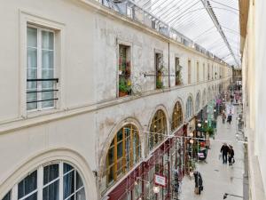 パリにあるWelkeys - Choiseul Apartmentのガラス天井の建物を歩く人々の通り