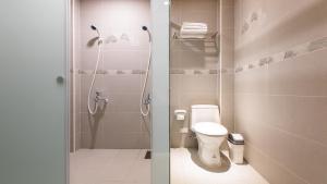 a bathroom with a shower with a toilet and a sink at Araucaria Residence in Huxi