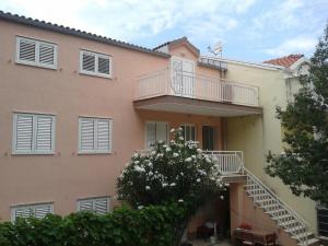ein Apartmenthaus mit einem Balkon und einer Treppe in der Unterkunft Apartments Lončarević in Slano