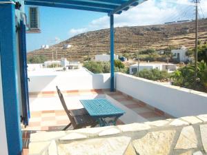 a patio with a table and chairs on a balcony at Serifos Palace in Livadakia
