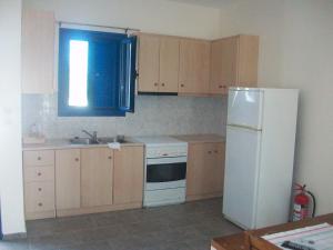 a kitchen with a white refrigerator and a sink at Serifos Palace in Livadakia
