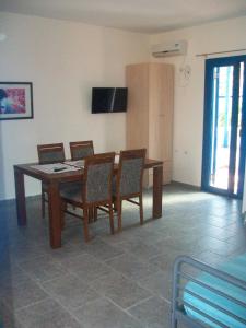 a dining room with a wooden table and chairs at Serifos Palace in Livadakia