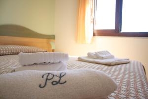 a bed with two towels on top of it at Residence Punta Longa in Favignana