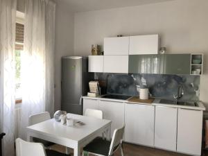 a kitchen with white cabinets and a table with chairs at Appartamento a Viterbo in Viterbo