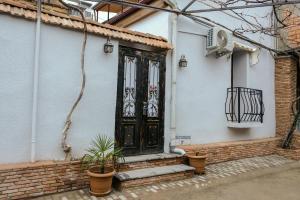 a black door on a white building with potted plants at 3 Studio in Tbilisi City