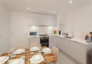 a kitchen and dining room with a table and chairs at 8 Woolacombe West - Luxury Apartment at Byron Woolacombe, only 4 minute walk to Woolacombe Beach! in Woolacombe
