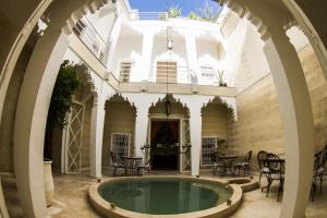 a courtyard with a pool in the middle of a building at Riad THALGE in Marrakesh