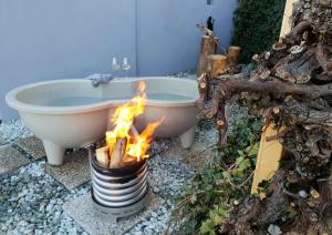 a bath tub on fire next to a fire pit at Weinloft III by Weinlofts in Eisenberg an der Pinka