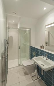 W łazience znajduje się prysznic, toaleta i umywalka. w obiekcie 8 Woolacombe West - Luxury Apartment at Byron Woolacombe, only 4 minute walk to Woolacombe Beach! w mieście Woolacombe