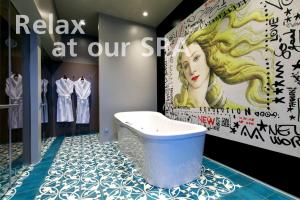 een badkamer met een ligbad en een bord met de tekst relaxen in onze spa bij Boutique Hotel Villa Perlov in Sint-Petersburg
