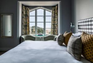 a bedroom with a bed and a large window at Crown and Castle in Orford