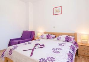 ein Schlafzimmer mit einem Bett mit einem lila Band darauf in der Unterkunft Apartments Ljuba - in center & close to the beach in Duba