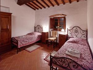 um quarto com 2 camas, uma mesa e um espelho em Agriturismo Podere Cortilla em Volterra