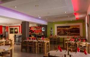 a restaurant with tables and chairs in a room at Hôtel Les Italiens in Biscarrosse