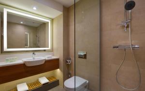 a bathroom with a shower, toilet and sink at Courtyard by Marriott Moscow City Center in Moscow