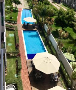 an overhead view of a swimming pool with an umbrella at Porto Plaza Flat - 404 in Porto De Galinhas