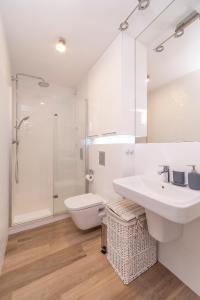 a bathroom with a sink and a toilet and a shower at Apartments Secret Garden Sopot by Renters in Sopot