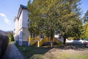 a house with a yellow slide next to a tree at Apartments Secret Garden Sopot by Renters in Sopot