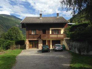a house with two cars parked in front of it at Chalet les Lurins in Villarlurin
