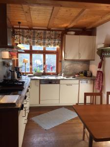 a kitchen with white cabinets and a large window at Rhöner Landhaus mit viel Flair in Gersfeld