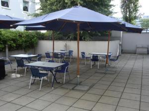 
a patio area with tables, chairs and umbrellas at Ibis budget Wien Sankt Marx in Vienna
