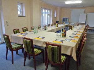 une salle de conférence avec de longues tables et chaises dans l'établissement Hotel Rauch, à Ettringen