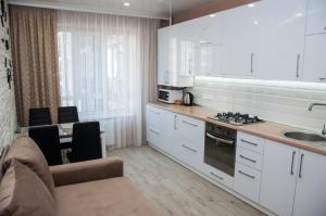uma cozinha com armários brancos e uma bancada em СУЧАСНА НОВА КВАРТИРА em Lutsʼk