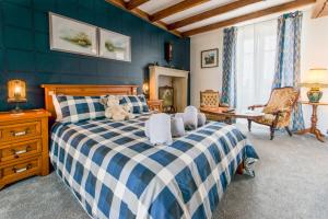 1 dormitorio con 1 cama grande y pared azul en AUBERGE DU NOYER, en Londigny