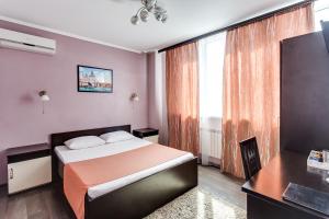 a bedroom with a bed and a large window at Venecia Hotel in Rostov on Don