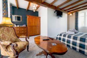a living room with a table and a bed at AUBERGE DU NOYER in Londigny
