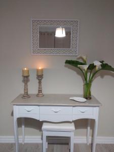 escritorio blanco con 2 velas y espejo en Lagoa´s House, en Lagoa
