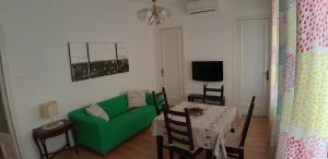 a living room with a green couch and a table at Piso Zona Plaza España, junto a Montjuic, in Barcelona