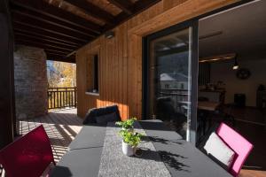 un patio con mesa y sillas en una terraza en T4 8 personnes de grand standing classé 4 étoiles en plein centre de Saint Lary Soulan en Saint-Lary-Soulan