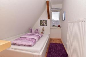 a bedroom with a bed with a purple blanket at Ferienwohnung am Hafen in Lübbenau