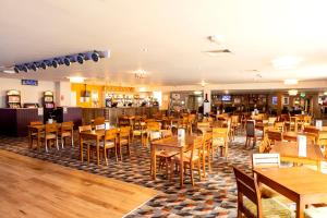 a restaurant filled with wooden tables and chairs at Camping Pods, Marlie Holiday Park in New Romney