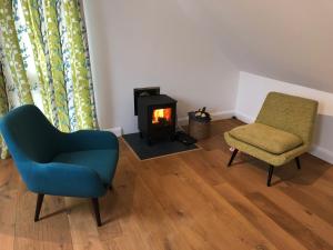 ein Wohnzimmer mit einem Stuhl und einem Kamin in der Unterkunft The Bamboo Lodge - B&B / self-catered apartment in Ashford