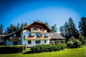 a large white house with a wooden roof at fanning 91 (zur Veitlerin) in Mariapfarr