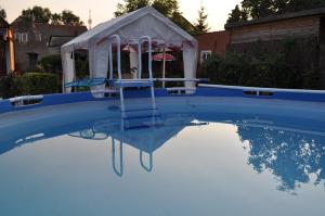 a slide in a pool with a house on top of it at Apartament Joanna in Tolkmicko