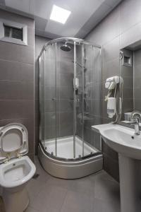 a bathroom with a shower and a toilet and a sink at Diplomat Suites in Baku