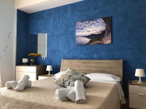 a blue bedroom with a bed with towels on it at New Royal in Agerola