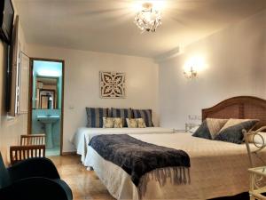 a bedroom with a large bed and a chandelier at Hostal Enriqueta in Marbella