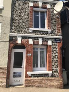 a brick building with two windows and a door at Les sources Yportaises in Yport