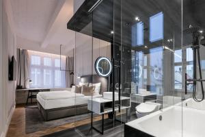 a bedroom with a bed and a bathroom with a mirror at Pytloun Boutique Hotel Prague in Prague