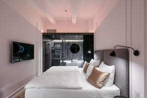 a bedroom with a bed with white sheets and pillows at Pytloun Boutique Hotel Prague in Prague