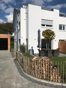 una casa blanca con una valla y una sombrilla en Ferienhaus Albert, en Owingen