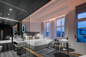 a bedroom with a bed and a bathroom with a tub at Pytloun Boutique Hotel Prague in Prague